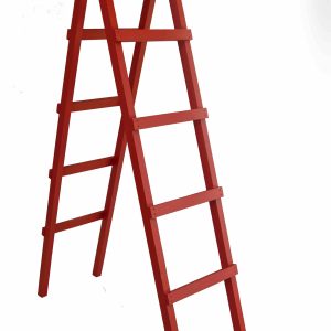 Red wooden ladder with white shelves